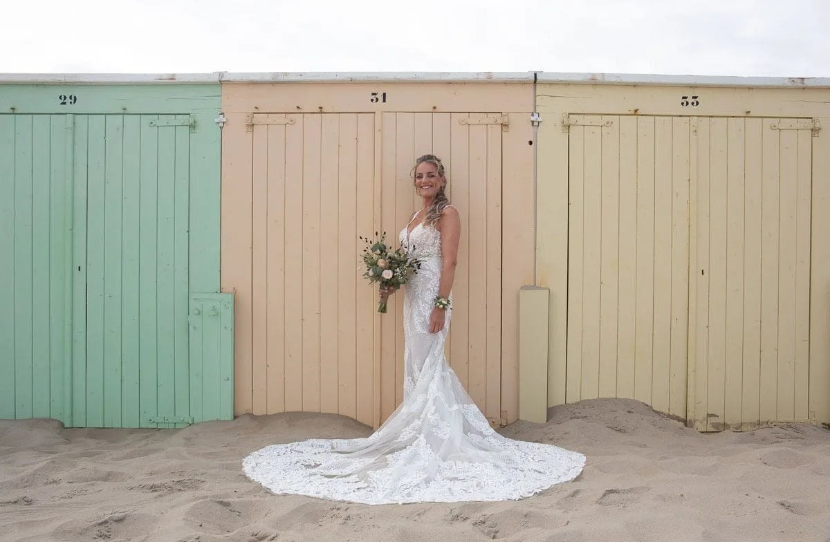 Marlisa stralend in haar bruidsjurk op het strand